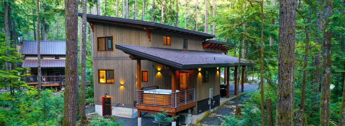 A modern cabin with a hot tub on its deck in Glacier Springs